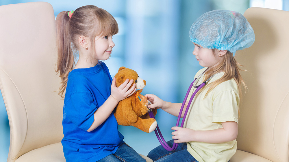 两个女孩和泰迪熊玩医生游戏