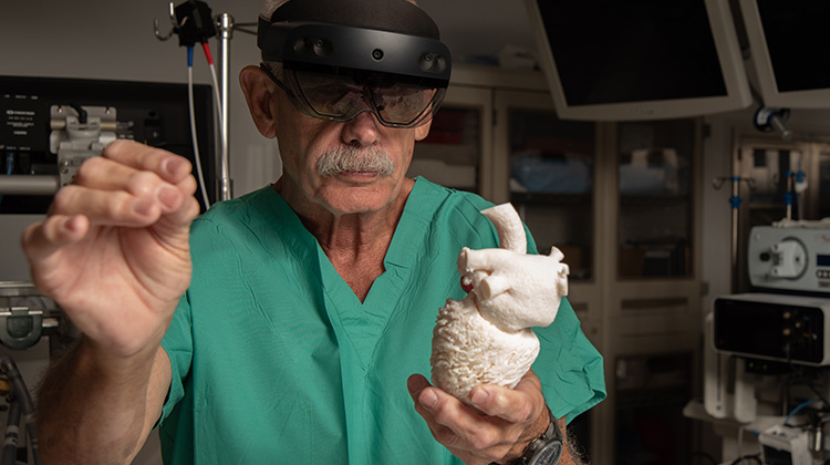医生手持3d渲染心脏，同时戴上虚拟现实耳机