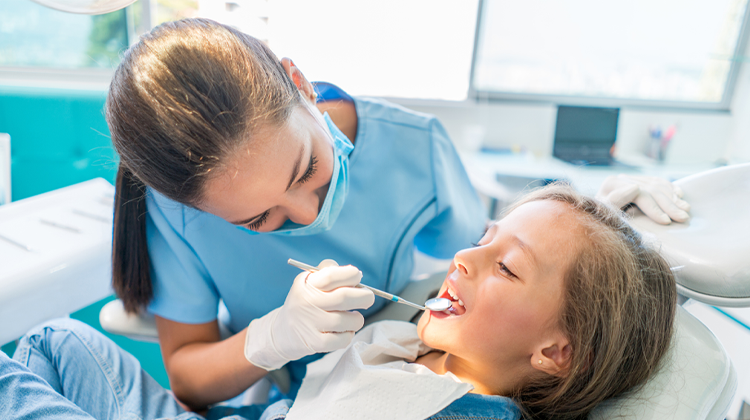 Odontóloga haciendo UN exámen dental en una niña